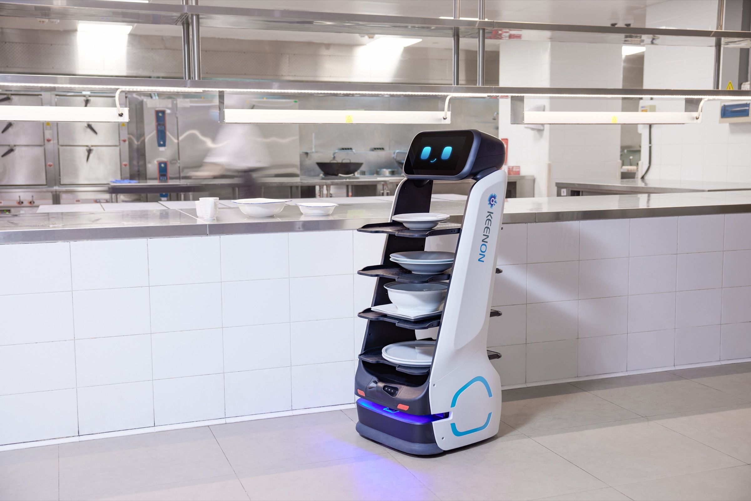 Delivery robot loaded with plates at a commercial kitchen pass