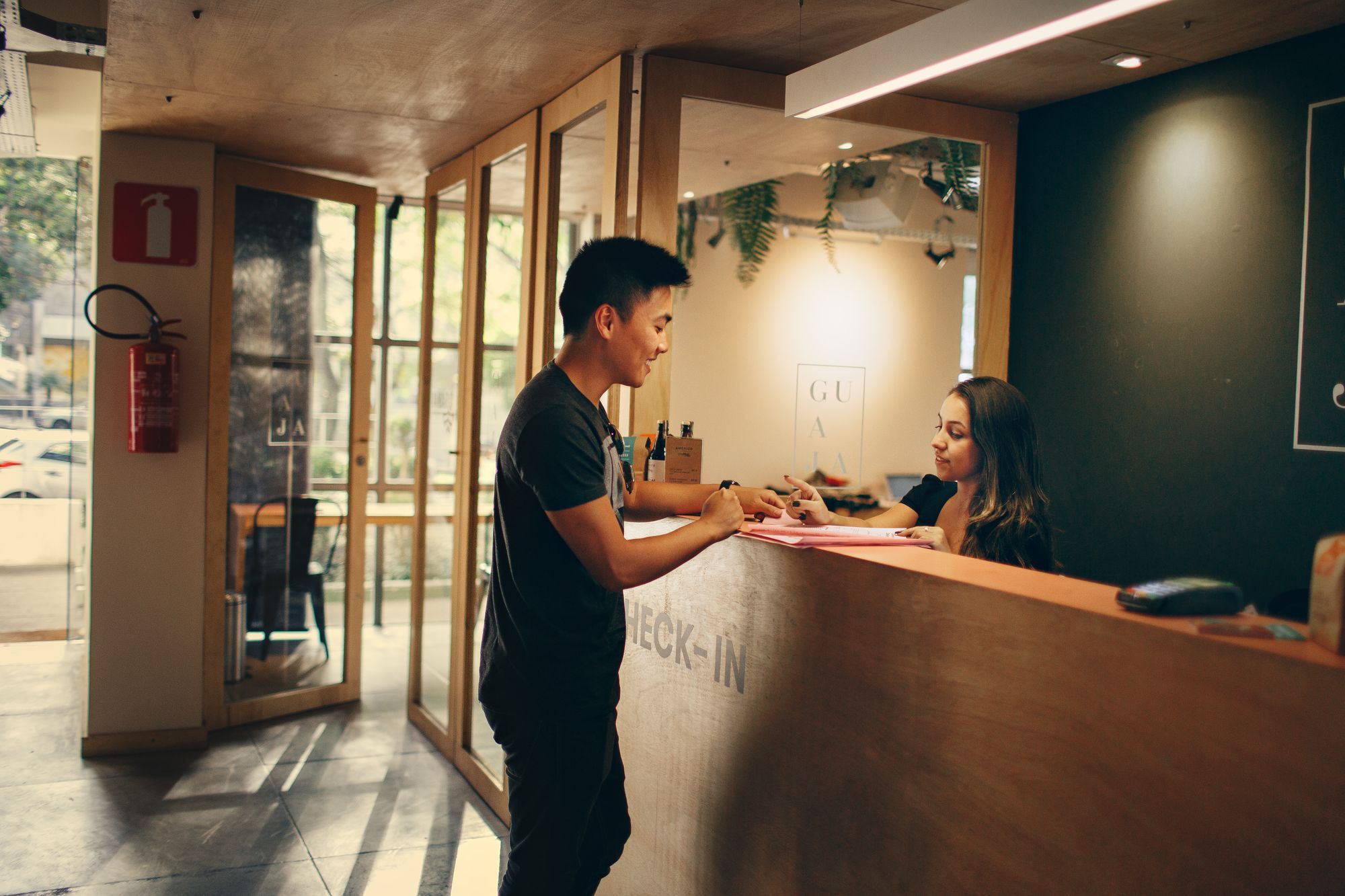 A guest checking in with a receptionist at a hotel front desk