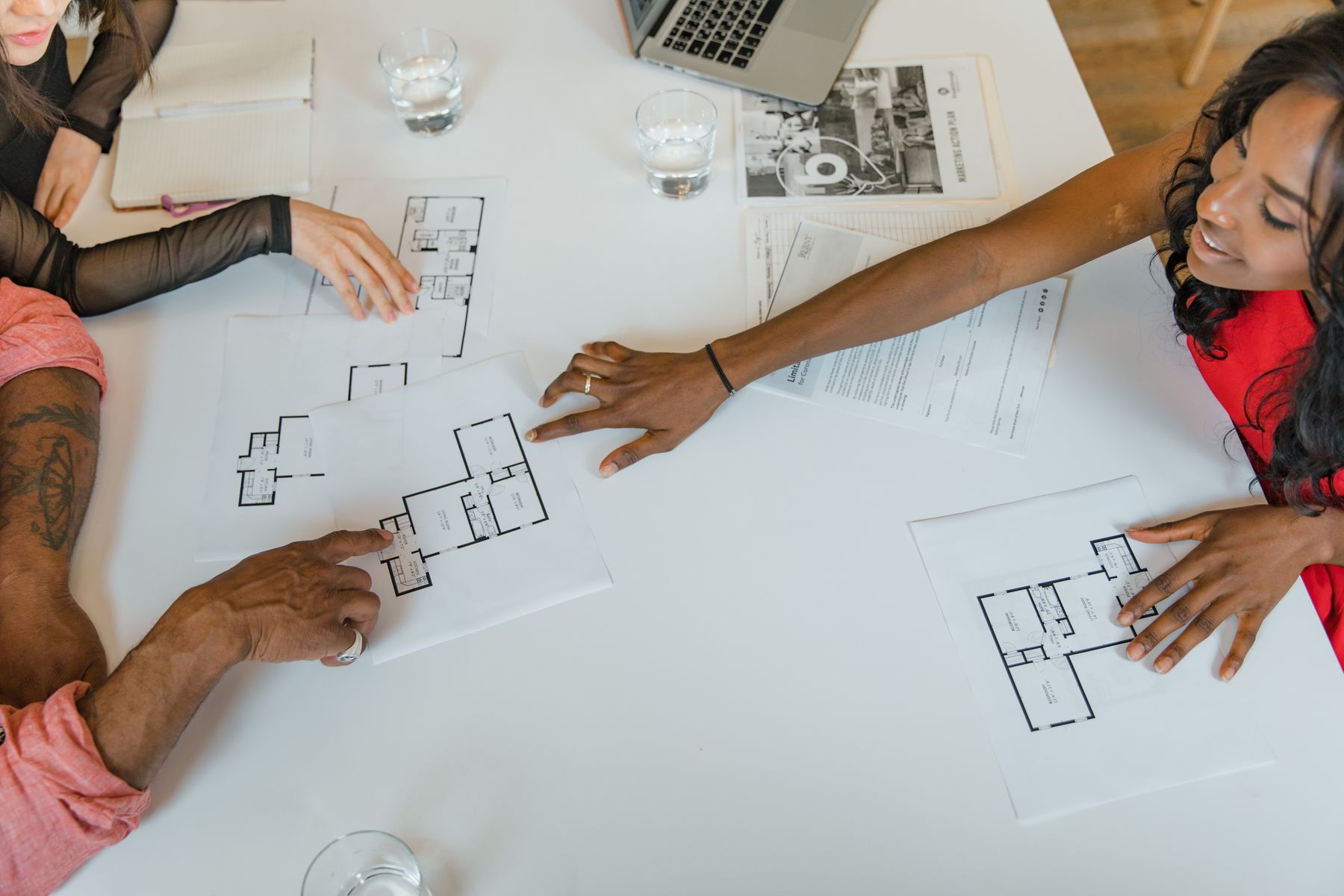 A team reviewing floor plans and notes around a table